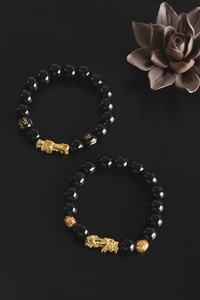 Detail of black obsidian beads with golden Pi Xiu and engraved mantra charm bracelets