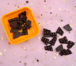 Detailed macro view of chocolate bar miniatures in an orange box for DIY phone cases