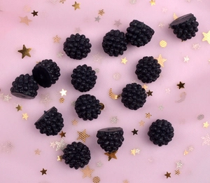 Macro detail of black resin blackberry charms for DIY phone case crafts and accessories