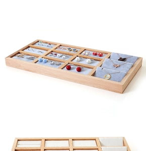 Detail of 12-slot beech wood jewelry tray with grey velvet lining for rings and earrings