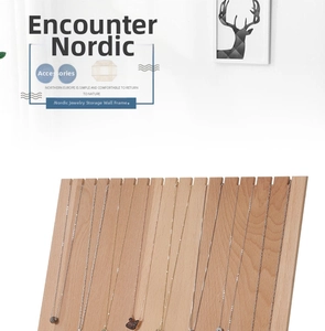 Detail of wooden necklace display stand with necklaces hanging on minimalist slots