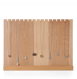 Detail of wooden necklace display stand with multiple slots for jewelry organization