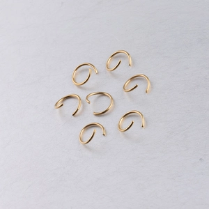 Close-up of seven 10mm gold-plated stainless steel open jump rings for DIY jewelry making