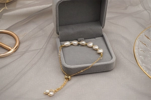 Close-up of golden freshwater pearl bracelet inside a grey velvet jewelry gift box