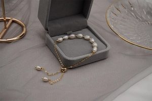 Detail of adjustable freshwater pearl and gold titanium chain bracelet in a jewelry box
