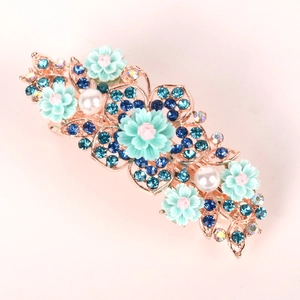 Detailed close-up of a floral hair clip with mint resin flowers and blue rhinestones