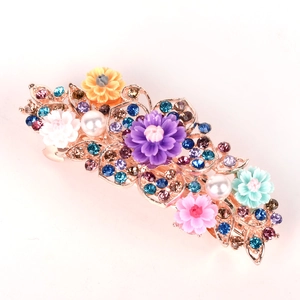 Detail of flower hair comb with colorful resin blossoms and inlaid sparkling rhinestones