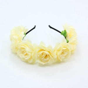 Close-up of artificial light yellow roses on a black floral headband for wedding hair