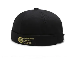 Detail view of black docker hat showing twill cotton fabric and yellow woven label