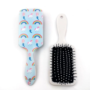 Detail of blue mermaid and unicorn print on plastic air cushion paddle hairbrush