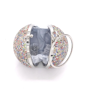 Macro view of crystal spherical evening bag with silver ring handle and satin lining