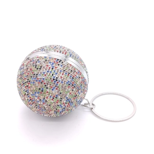 Macro shot of spherical evening clutch bag with colorful rhinestones and silver metal handle