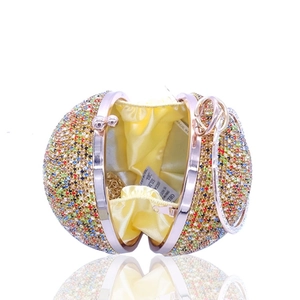 Detail view of colorful rhinestone round evening bag with yellow satin lining and gold chain