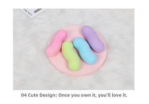 Close-up of four colorful peanut-shaped rubber chew toys for dogs on a pink tray