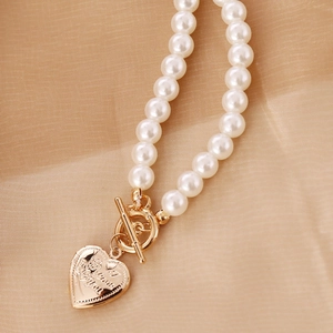 Vintage heart locket pearl necklace with I Love You engraving on soft beige satin