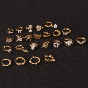 Detalle macro de varios pendientes de aro dorados con dijes de circonita y motivos