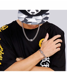 Detail shot of men's chunky silver Cuban link necklace and bracelet set on a model