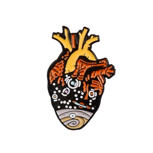 Detailed macro view of an anatomical heart enamel pin with vibrant yellow and blue colors