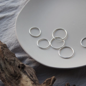 Minimalist S925 sterling silver ring set on beige ceramic tray with soft shadows