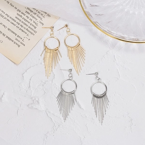 Elegant gold and silver long metal tassel drop earrings on minimalist aesthetic background
