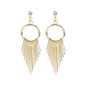 Close-up of gold geometric fringe earrings with crystal studs and metal tassels
