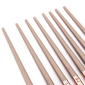 Detailed view of matte beige handles and rose gold ferrules of professional makeup brushes