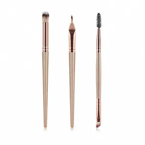 Detailed set of champagne gold eye and brow brushes with fiber bristles on white background