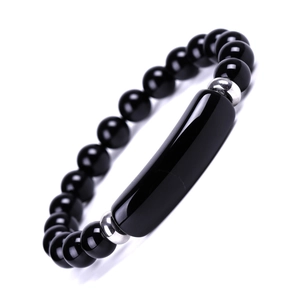 Macro detail of polished black beaded bracelet with silver spacers and curved bar link