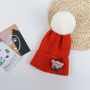 Détail d'un bonnet de Noël rouge avec pompon blanc et figurine de renne mignonne cousue