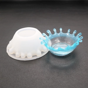 Detail of crown-shaped water drop silicone mold and blue resin finish on leather background