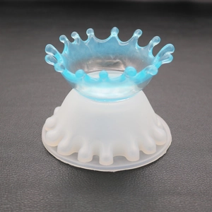 Detail of blue resin crown pendant and translucent silicone mold on leather background