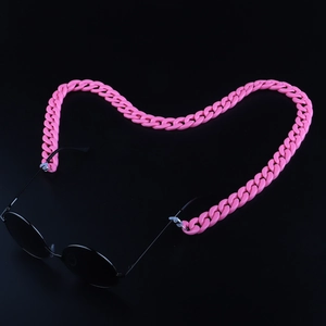 Pink acrylic eyewear chain for sunglasses arranged in a heart shape on a black background