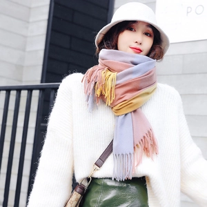 Thick plaid cashmere-like scarf with tassels in pink and blue worn by a model