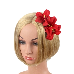Detail view of red faux orchids hair comb with three flowers worn on a mannequin