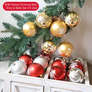 Close-up of 8cm gold painted Christmas balls with star patterns on pine branches