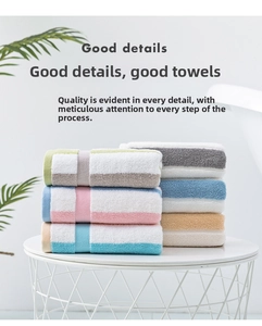 Detail of colorful striped cotton towels neatly rolled on a white geometric table
