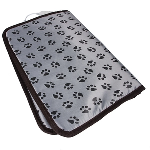 Détail d'un tapis chauffant gris pour animaux avec motifs de pattes et bordure marron renforcée