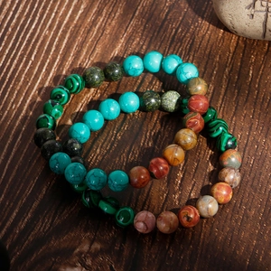 Ensemble de bracelets en perles de turquoise et malachite sur un fond en bois rustique