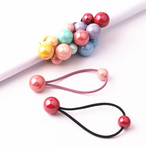 Dettaglio di perline colorate su elastici per capelli da bambina in rosa e rosso