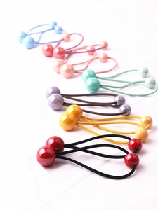 Dettaglio di elastici per capelli colorati con doppie sfere per bambine su fondo bianco