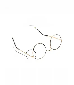 Detail of round metal glasses frame featuring golden hinges and comfortable nose pads