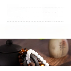 Detailed view of handmade Tiger Eye and White Turquoise beaded bracelet on wooden surface