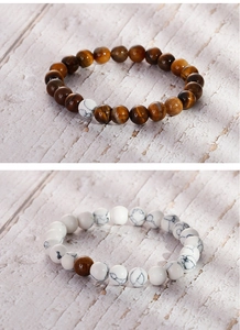 Detailed macro view of tiger eye and white turquoise beaded bracelets on a wood texture