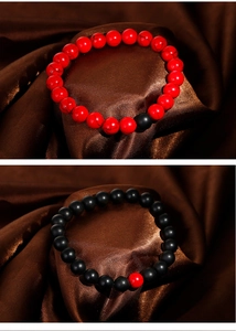 Detail of 8mm matte black onyx and red textured stone beads on brown satin fabric