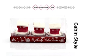 Three-piece red and white Christmas cabin candles in festive window display packaging box