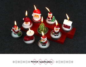 Detailed view of burning Christmas tea light candles shaped like Santa and trees