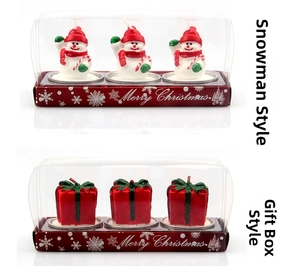 Detail of Christmas snowman and gift box shaped candles with metal base trays