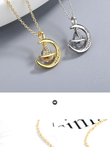 Macro shot of minimalist crescent moon and planet pendant necklaces in gold and silver