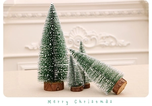 Dettaglio di quattro mini alberi di Natale innevati con basi in legno naturale decoro