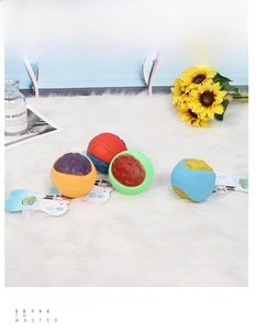 Macro detail of textured rubber squeaky balls for dog teething on a soft plush white rug